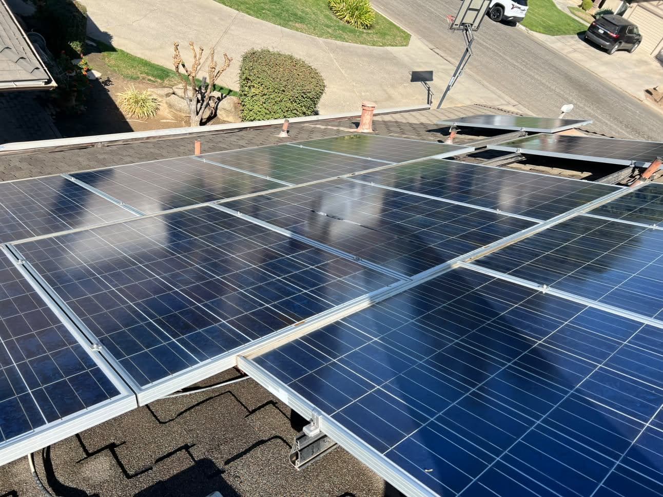 Wide view of a dusty residential solar array from the street