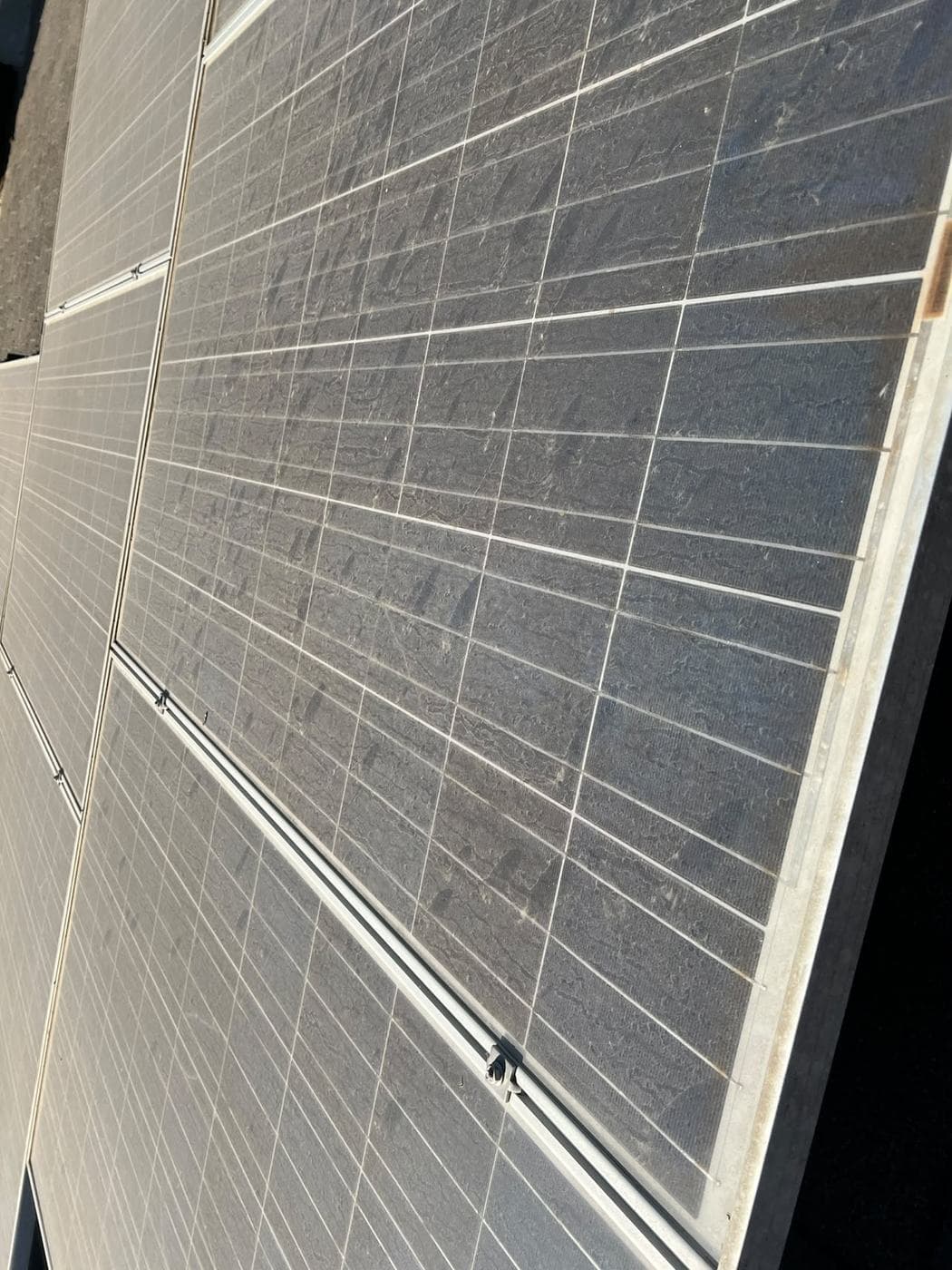 Close-up of a solar panel caked in dust and grime before cleaning